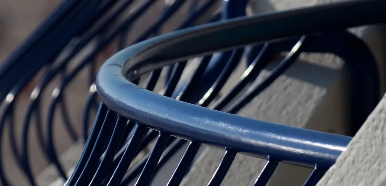 Curved dark blue steel balustrade with vertical balusters