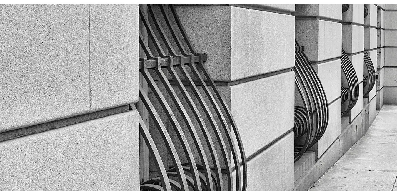 Curved steel window bars on a stone building