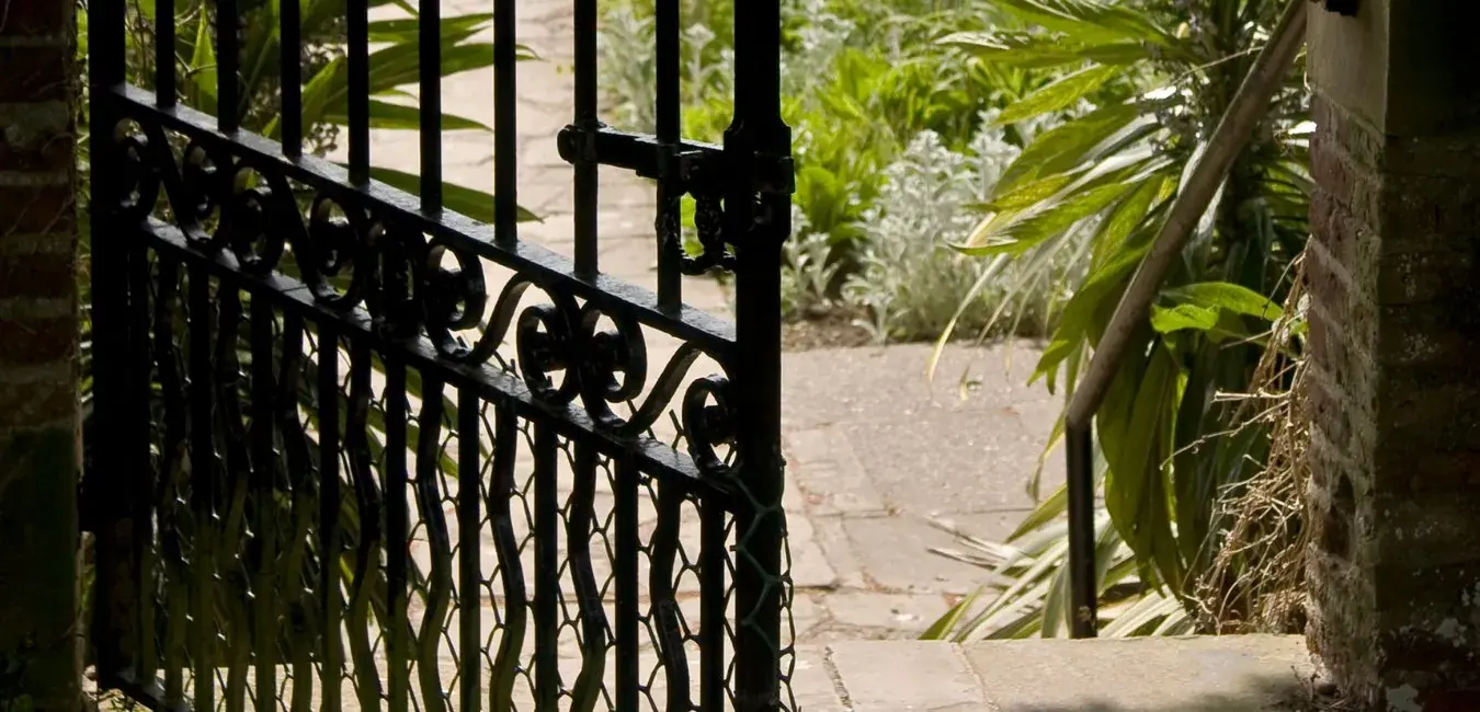Black steel pedestrian garden gate with scroll detailing