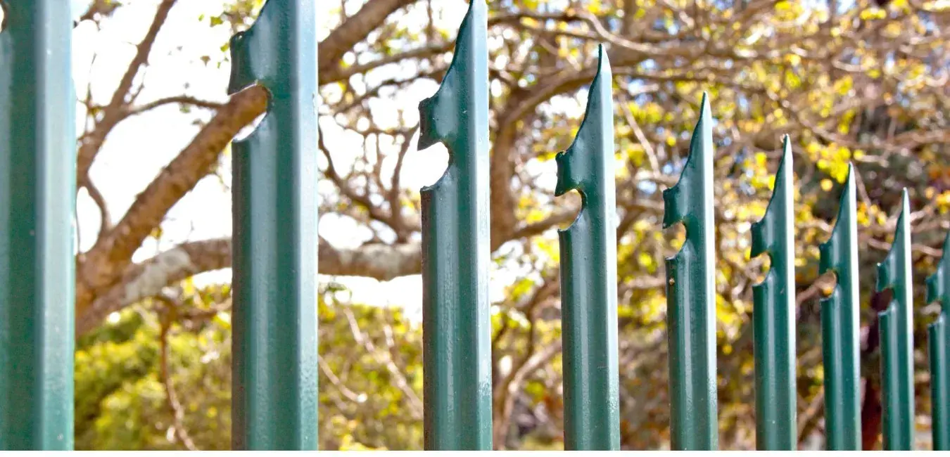 Green palisade fence pales with triple-spike tops